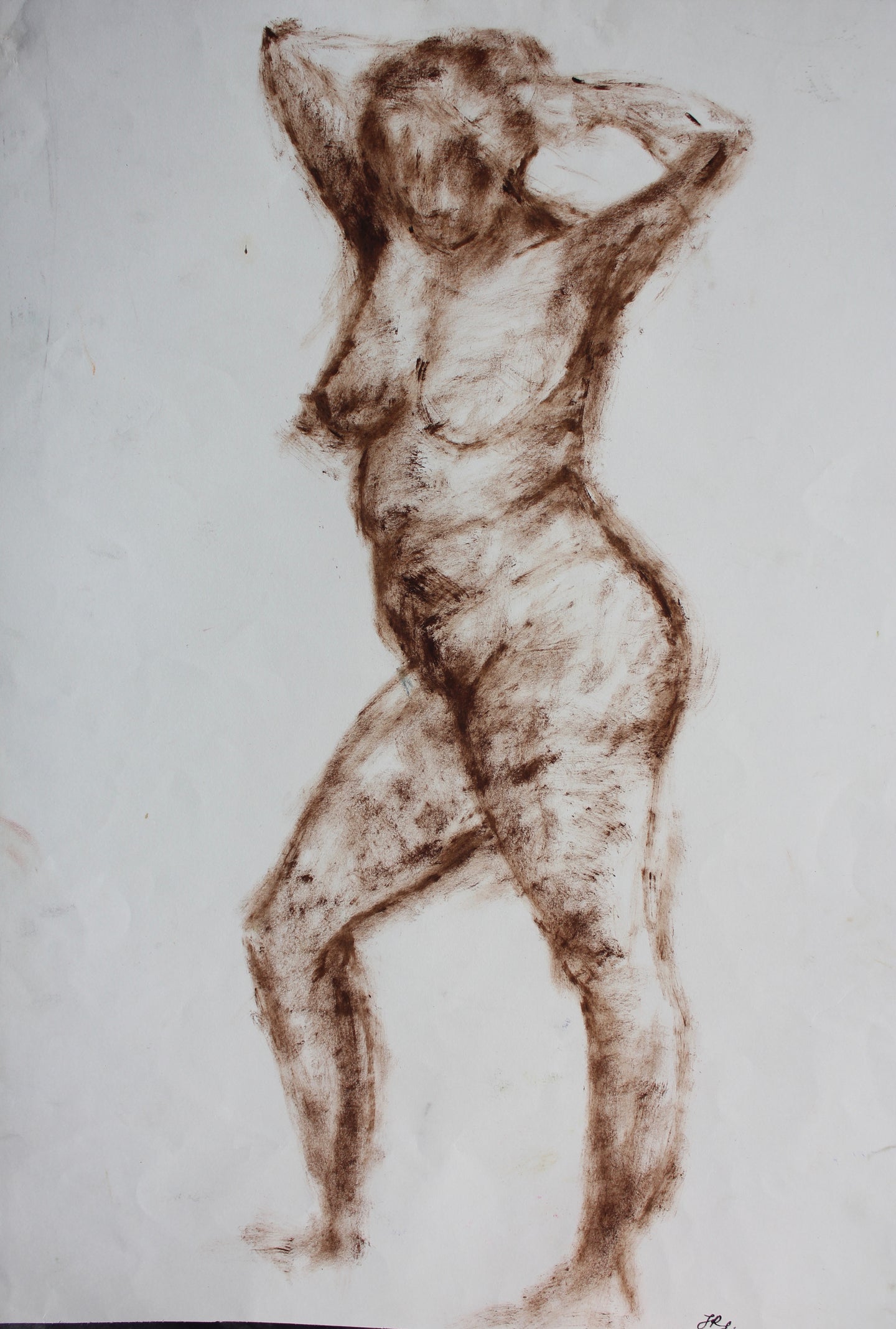 Nude woman standing holding hair